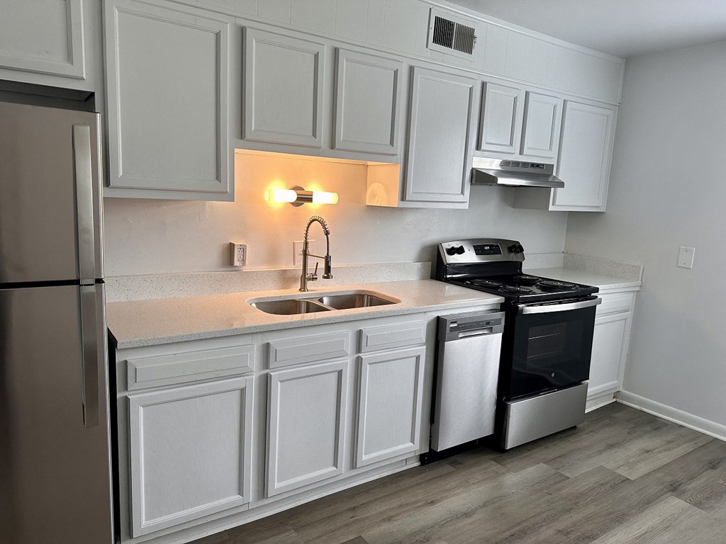a kitchen with white cabinets and a sink and a refrigerator