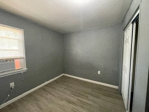 an empty room with gray walls and a window