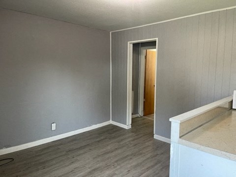 an empty living room with a door to a hallway