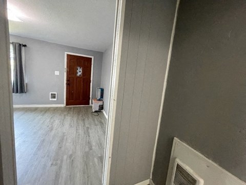a living room with a wooden floor and a door