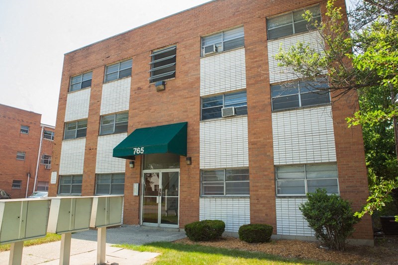 the front of a brick building with a green awning