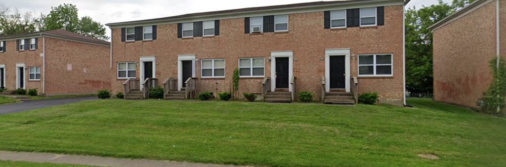 a brick building with a lawn in front of it