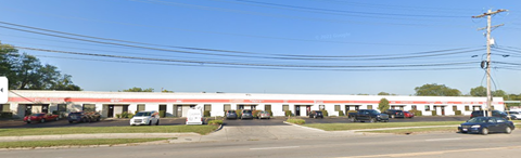 a motel with cars parked in a parking lot