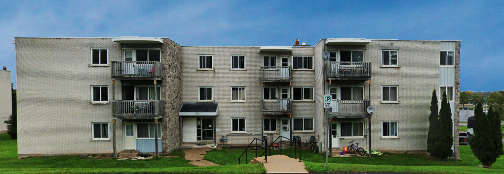 Apartment building with a balcony on the second floor.