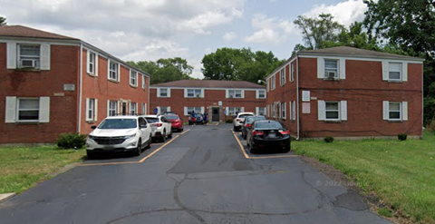 a row of brick apartment buildings with cars parked in front of them