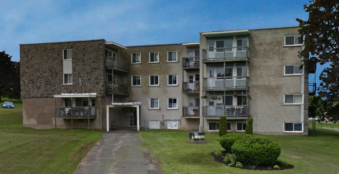 A large concrete building with a driveway in front.