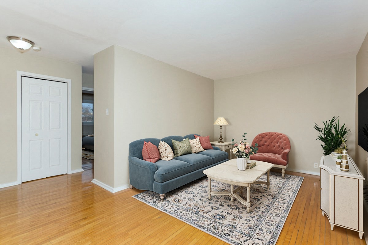 A living room with a blue couch, a red chair, and a white coffee table.