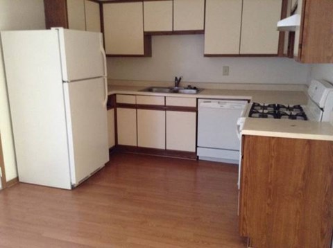 a kitchen with a white refrigerator and a sink