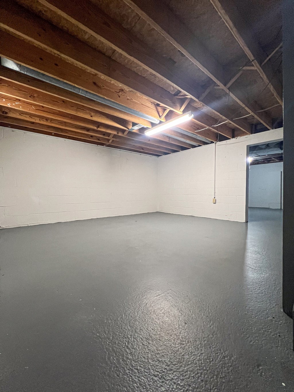 an empty basement with a concrete floor and white walls