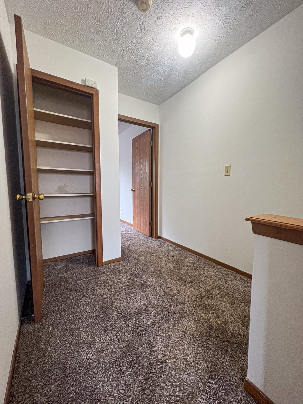 a hallway with a closet and a door to a bathroom