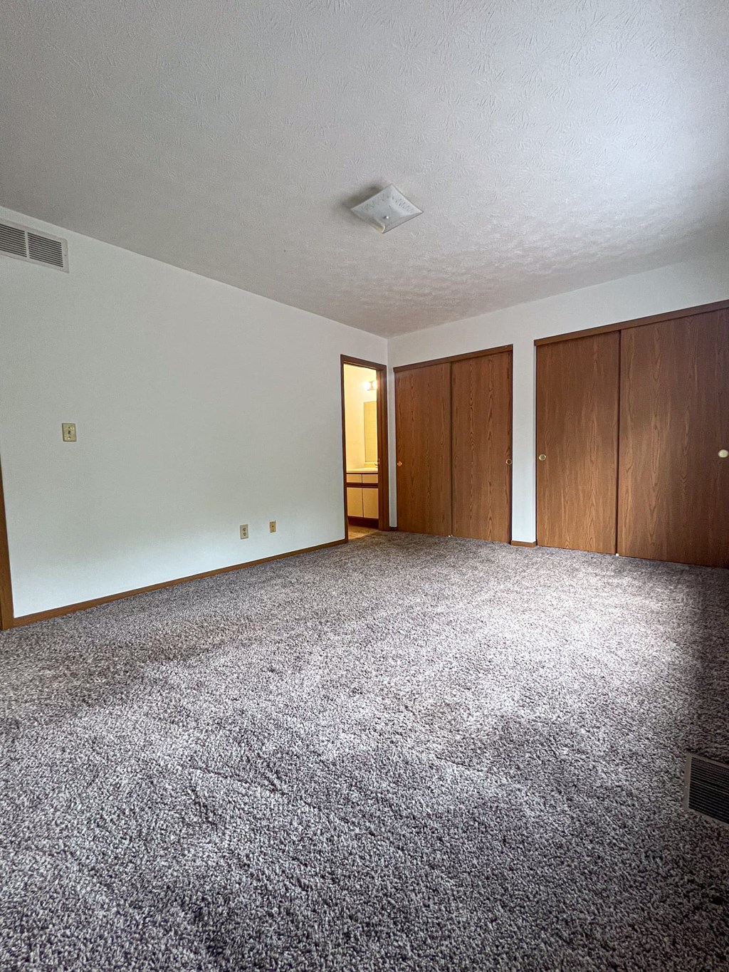 an empty living room with carpet and white walls