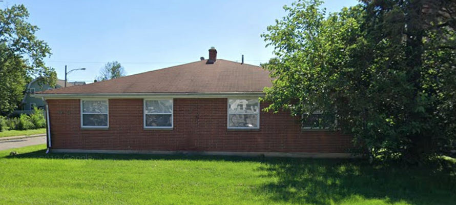 a brick house with a tree in front of it