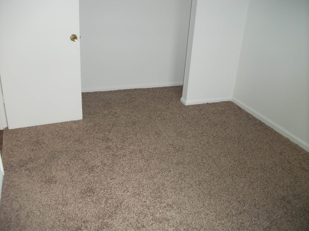an empty room with a carpeted floor and an open door