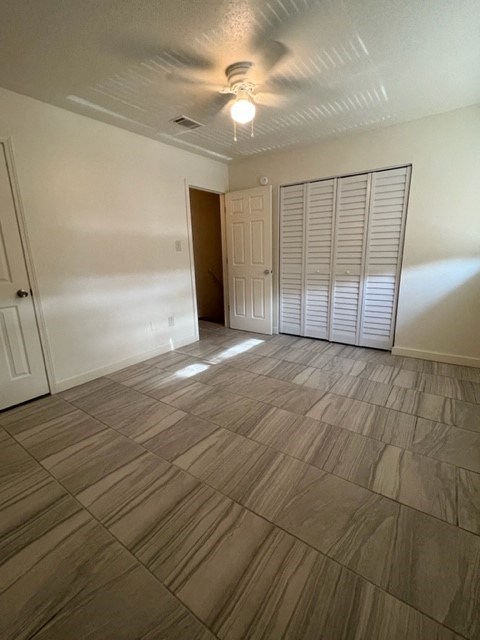 an empty living room with wooden floors and a ceiling fan