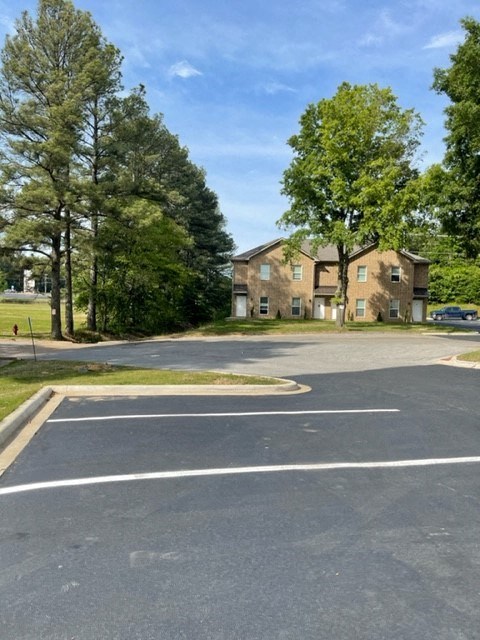 an empty parking lot in front of a brick building