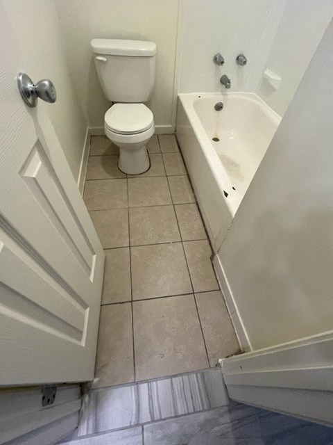 a bathroom with a toilet and a bath tub