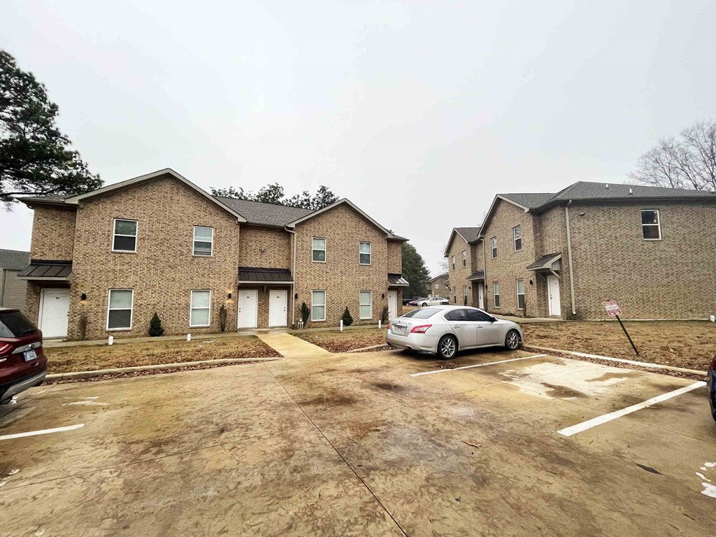 a car parked in a parking lot in front of two houses