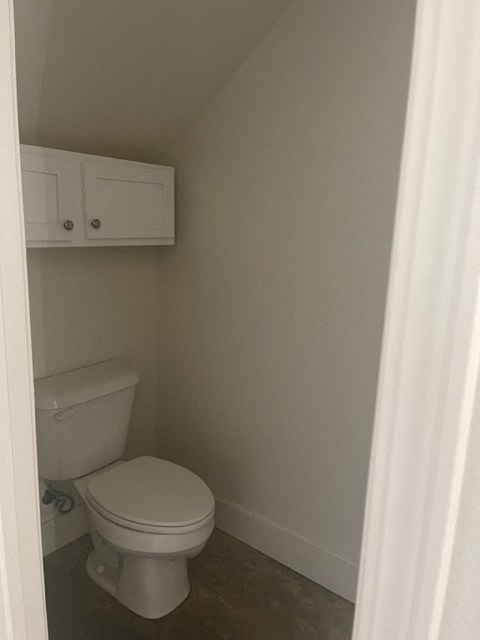 a small bathroom with a toilet and a white cabinet
