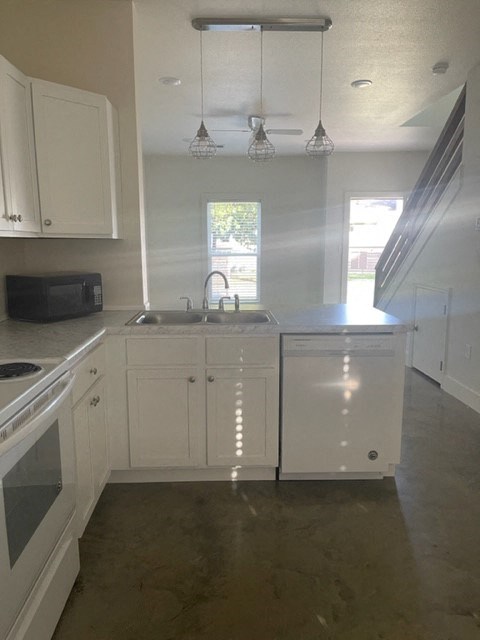 an empty kitchen with white cabinets and a sink