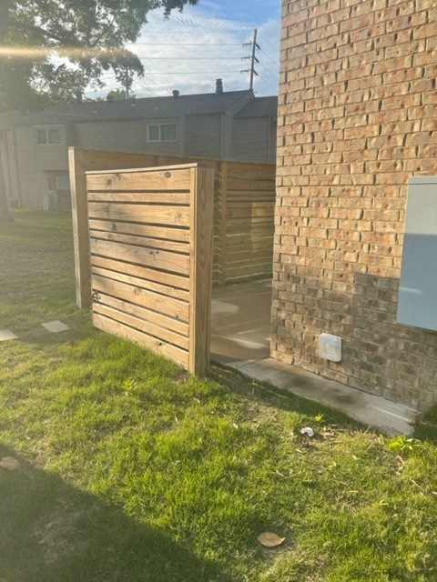 a wooden fence in front of a brick building