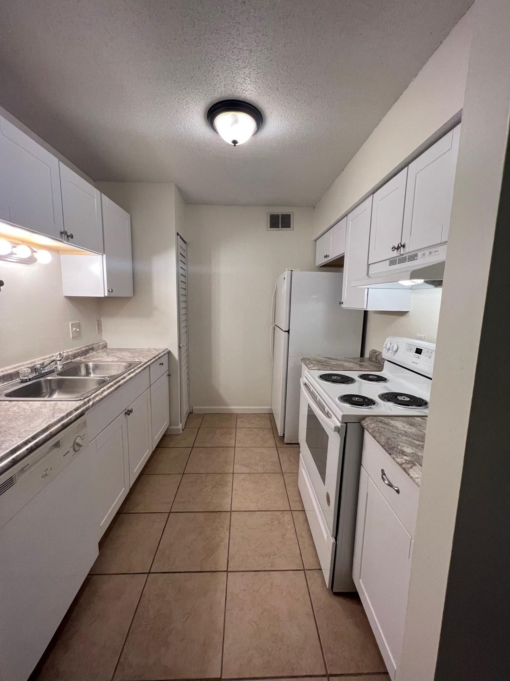 a kitchen with white cabinets and appliances and a white refrigerator