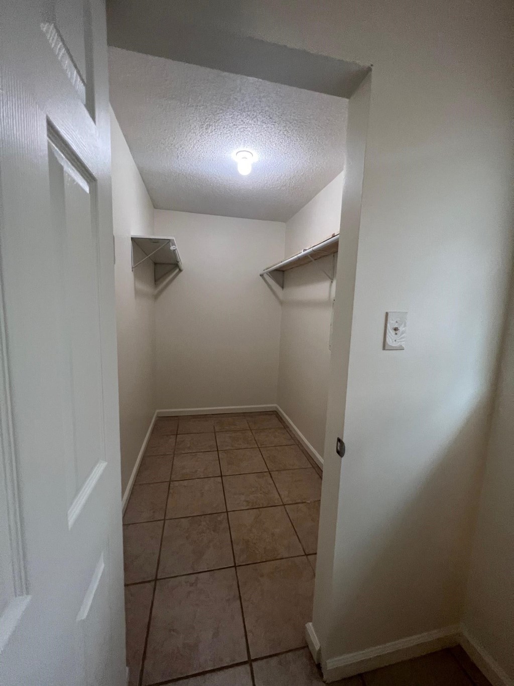 an empty room with a hallway with shelves and a ceiling