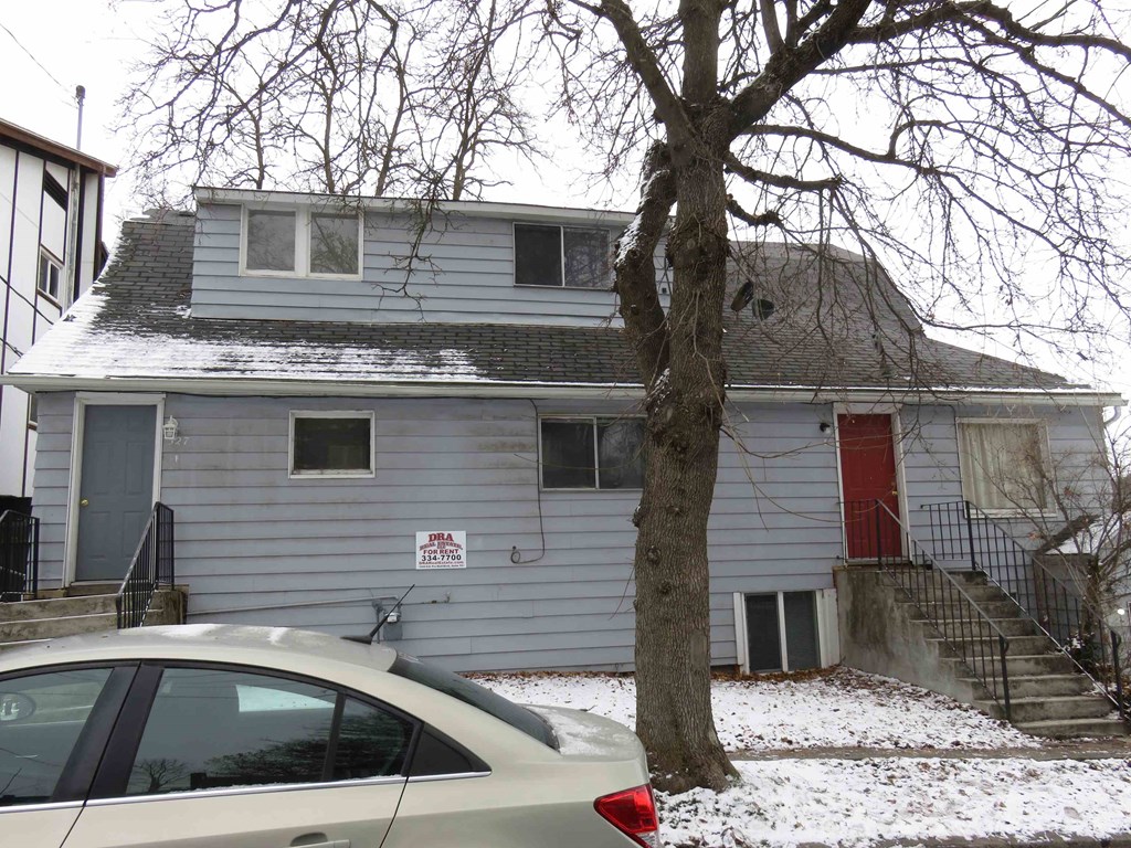 a house with a red door and a car in the snow
