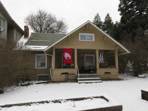 A small house with a red flag hanging on the front door.