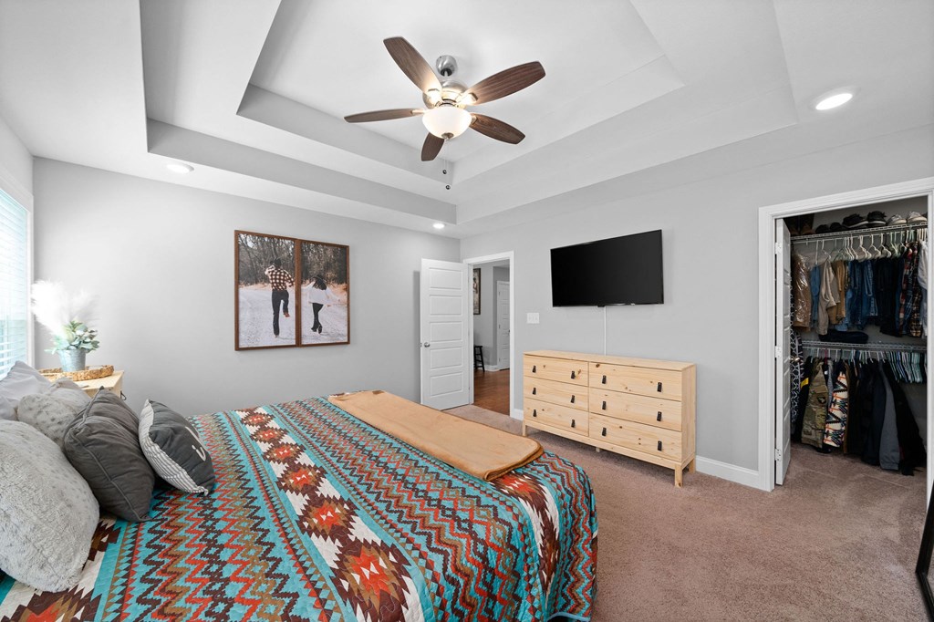 a bedroom with a bed and a ceiling fan