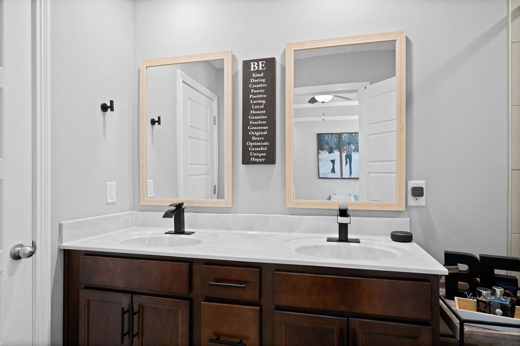 a white bathroom with two mirrors and a sink