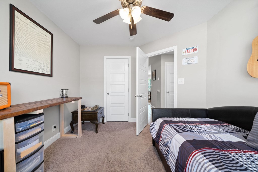a bedroom with a bed and a ceiling fan