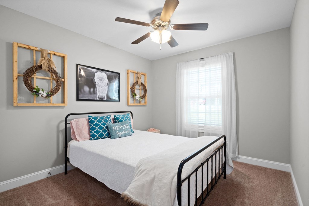 a bedroom with a bed and a ceiling fan