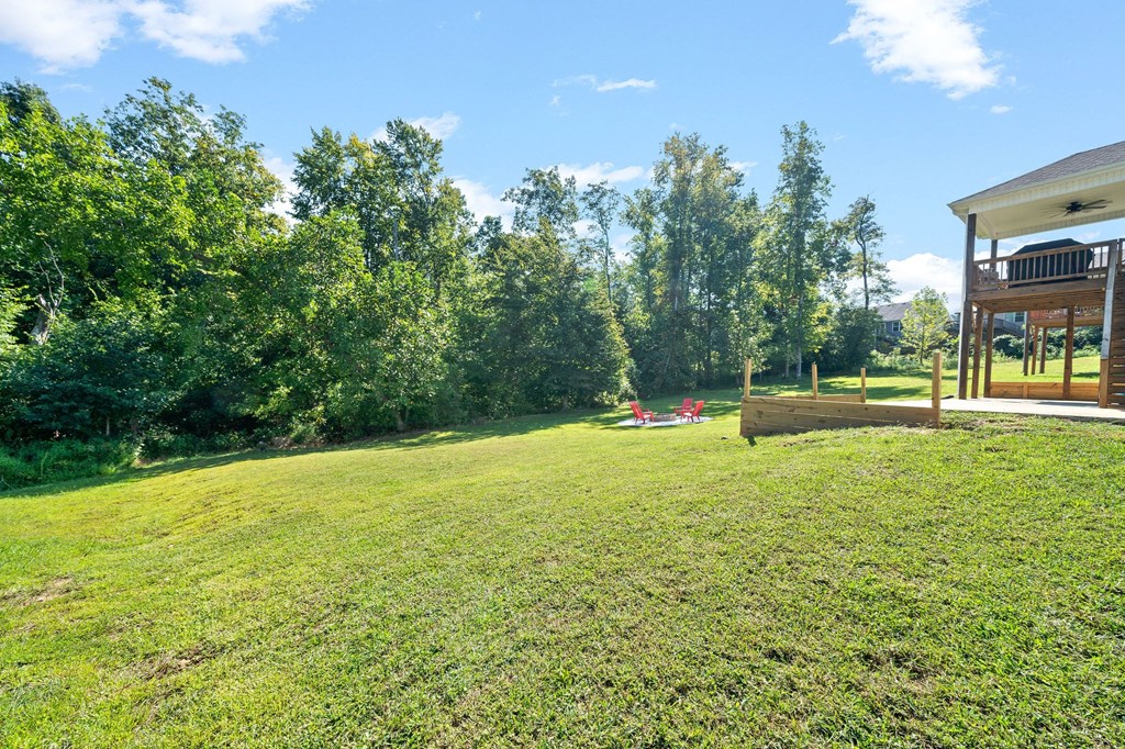 a yard with a house and trees in the background