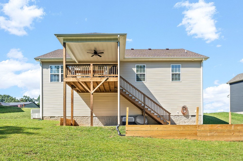 the back of a house with a deck and a yard