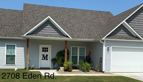 a gray house with a porch and a white door