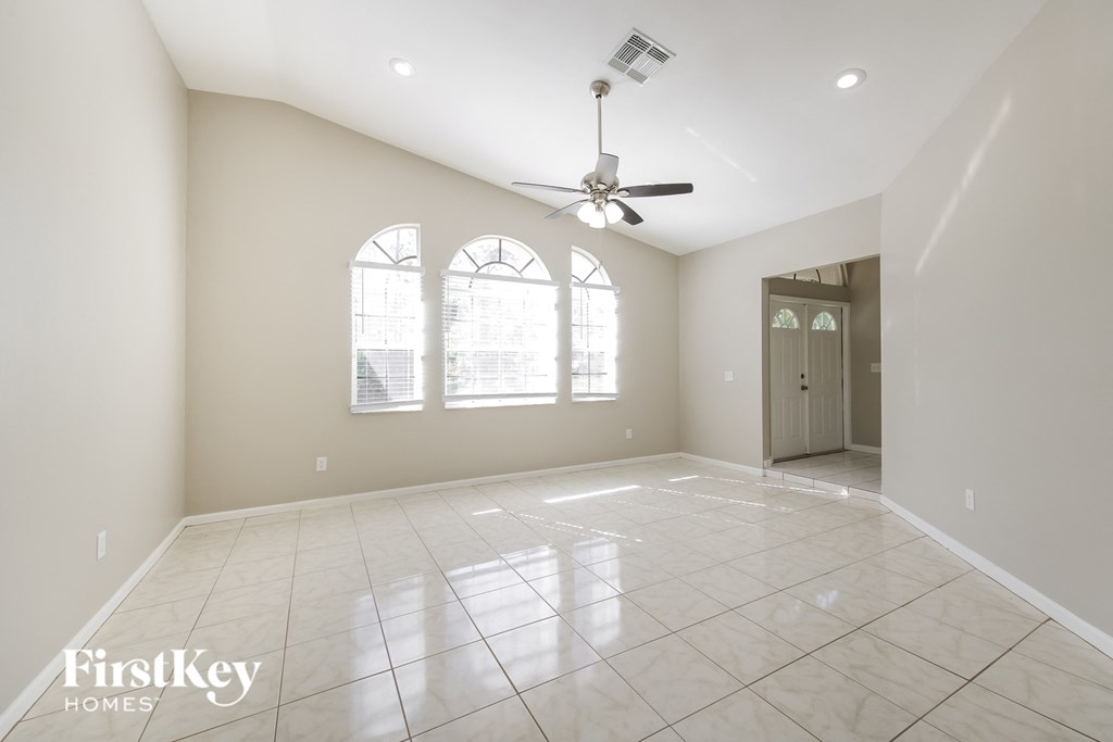 A spacious room with a fan and tiled flooring.