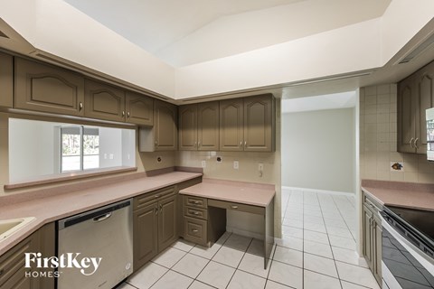 A kitchen with brown cabinets and a FirstKey Homes logo.