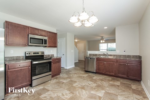 A kitchen with a tile floor and a stove top oven.