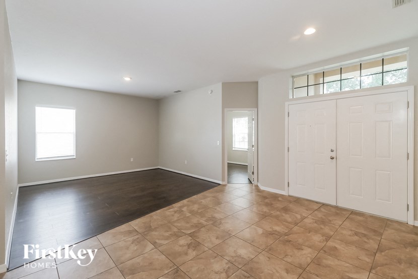A spacious room with a tiled floor and white walls.