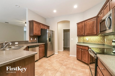 A kitchen with brown cabinets and a refrigerator.