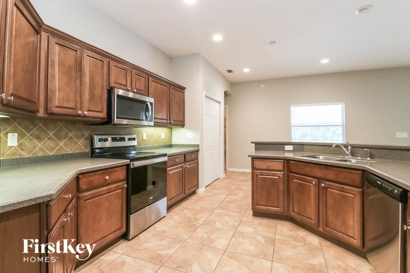 A kitchen with brown cabinets and a tiled backsplash.
