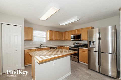 A kitchen with wooden cabinets and a stainless steel refrigerator.
