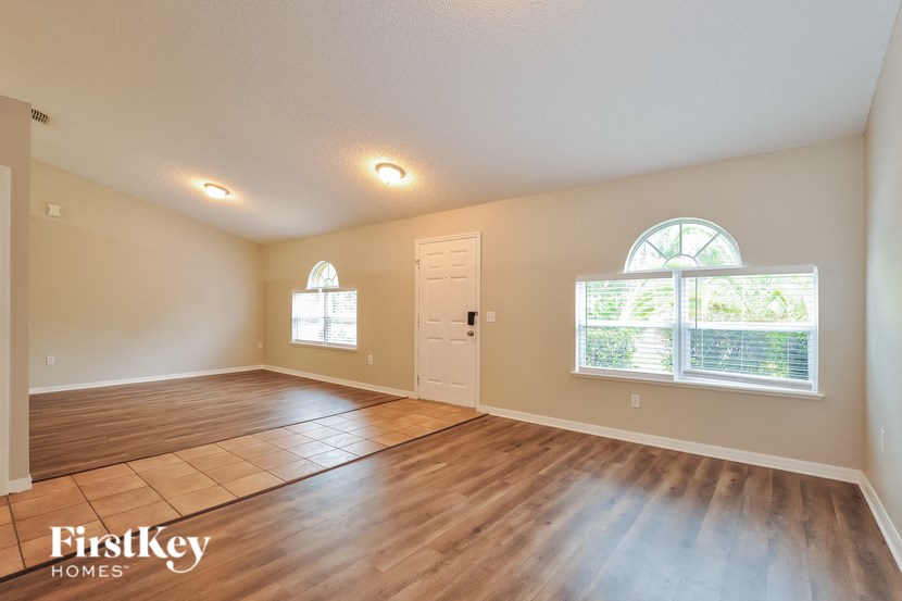 A spacious room with wooden flooring and a large window.