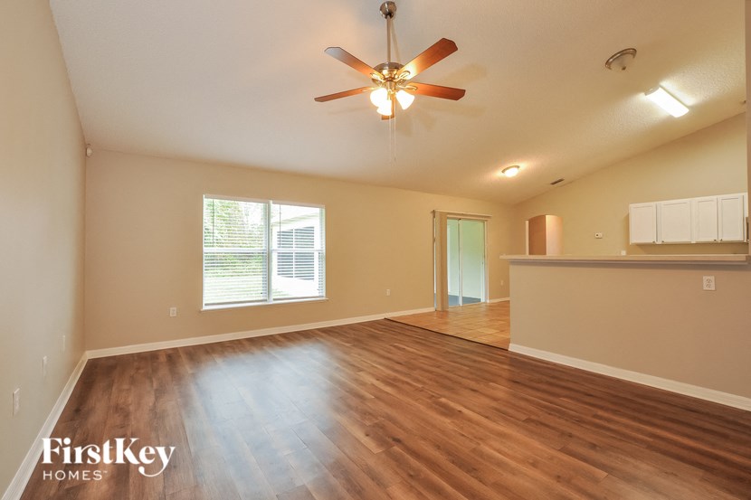 A spacious room with a ceiling fan and wooden flooring.