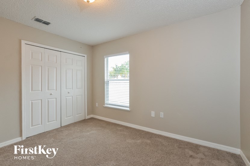 A room with a white door and a window with blinds.