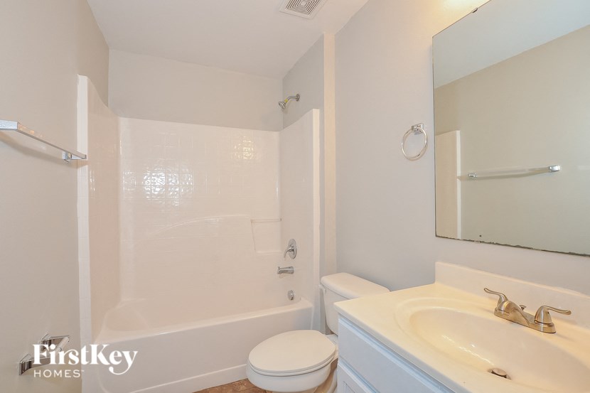 A white bathroom with a toilet, sink, and tub.