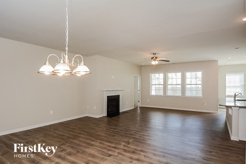 A spacious living room with wood flooring and a fireplace.