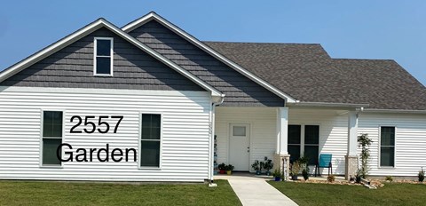 A white house with the number 2557 and the word Garden on the side.