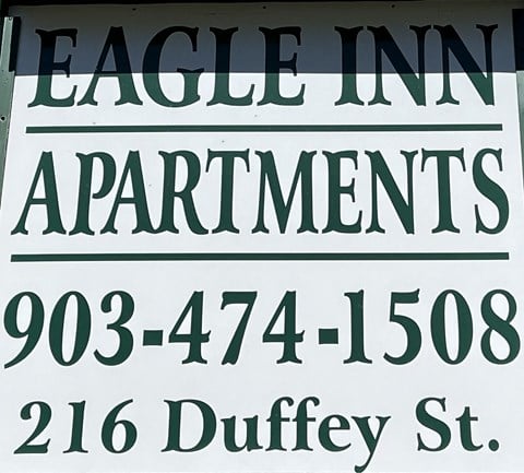 a street sign that reads eagle inn apartments