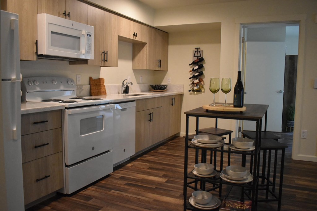 a kitchen with white appliances and a table with chairs